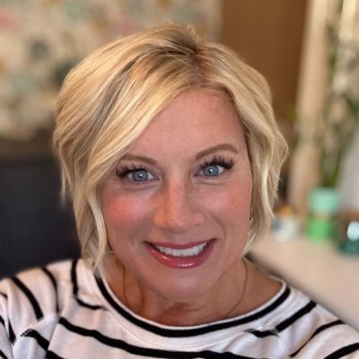 Chiropractic Albertville MN Carrie Cotch Meet The Team Carrie Cotch smiling and wearing a striped shirt.