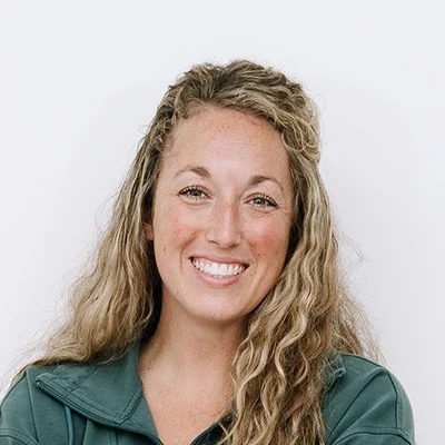 Doula & Health Coach Donielle Kasper Smiling In Front Of White Wall