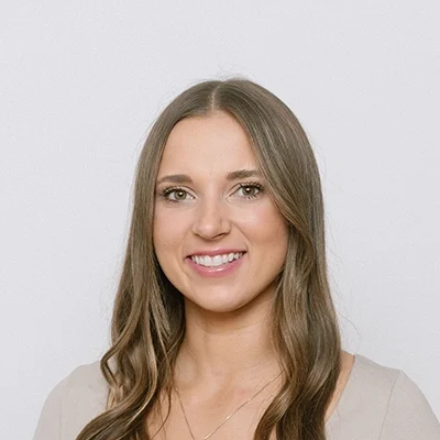 Chiropractor Breanna Samoleski Smiling In Front Of White Wall